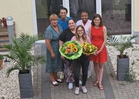 Natalie Magnussen mit Blumenstrauß zwischen Kolleginnen und Kollegen