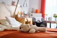 Ein Teddy liegt auf einem Pflegebett