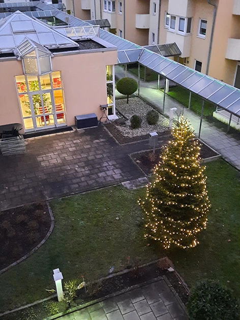 Ein leuchtender Christbaum steht im Hof der KINZIGALLEE