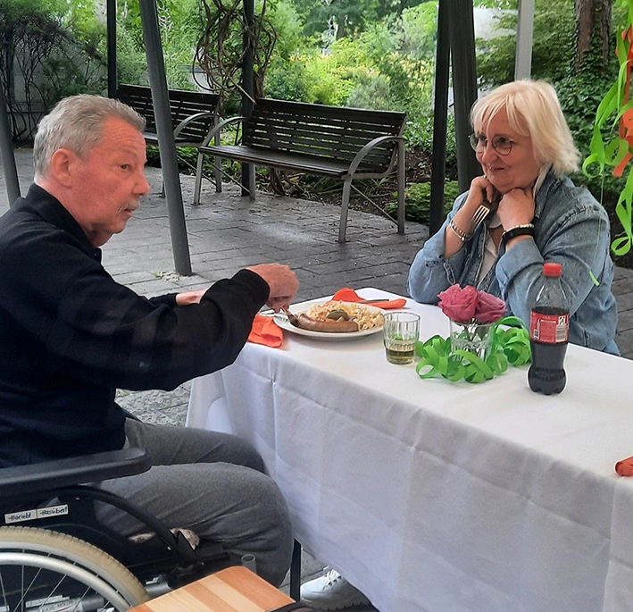 Mann und Frau am Tisch im Garten