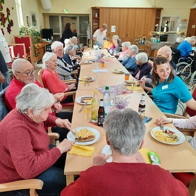 Seniorinnen und Senioren essen gemeinsam.