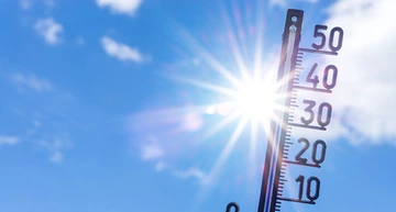 Ein Thermometer zeigt hohe Temperaturen. Sonne im Hintergrund.
