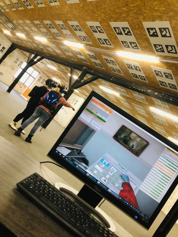 Auf dem Monitor sehen die avendi-Ausbildungsleiterin und der Virtual Reality Gestalter, in welchem virtuellen Raum die Azubis sich gerade bewegen.