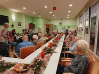 Bewohnerinnen und Bewohner des Pflegeheims PALAIS BOSE in Dessau nahmen an langen, festlich geschmückten Tafeln zur Weihnachtsfeier Platz.