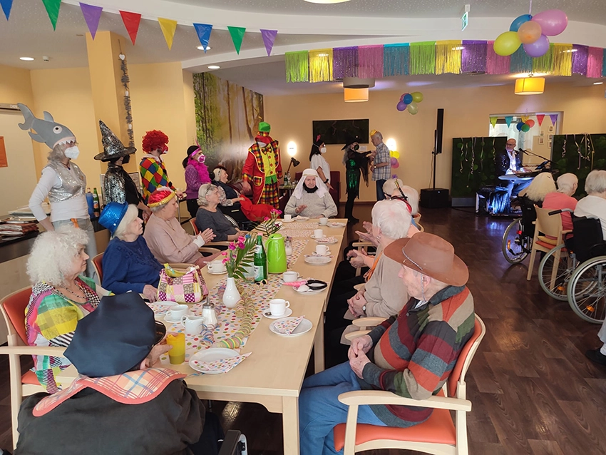 In der Cafeteria des CentroVerde lauschen die Bewohnerinnen und Bewohner der Büttenrede eines Seniors.