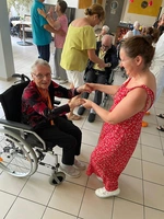 Mitarbeiterin tanzt mit Bewohnerin im Rollstuhl