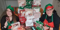 Als Weihnachtswichtel verpackten die Tagespflege-Leiterin und eine Kollgin von avendi mobil Weihnachtsgeschenke für die Mitarbeiterinnen und Mitarbeiter.