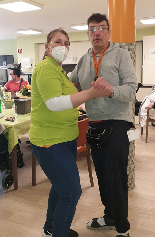 Bewohner und Pflegerin tanzen während der Musiktherapie in Wiesloch