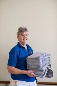 Mitarbeiterin der Hauswirtschaft bringt frische Handtücher
