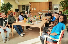 Schülerinnen und Schüler gemeinsam mit Senioren und Mitarbeitern in der Kinzigallee Kehl am Tisch beim Vorgespräch.