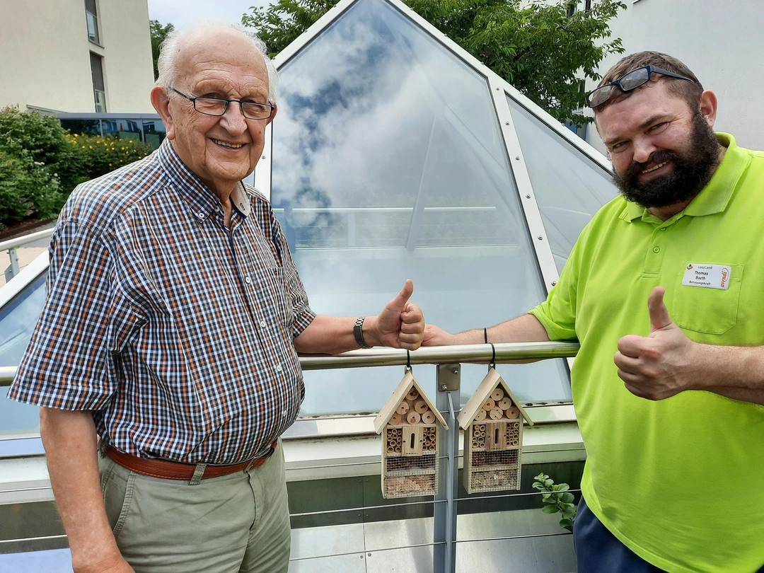 Pflegeheimbewohner und avendi-Mitarbeiter freuen sich über die neuen Insektenhotels für den Garten