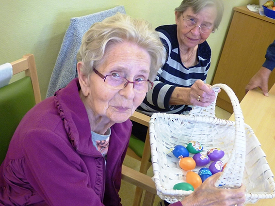 Zwei Bewohnerinnen mit einem Korb gefärbter Eier.