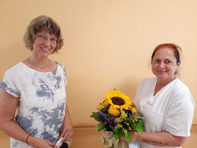 Anja Boudeau hält einen Blumenstrauß in der Hand, links von ihr steht Heimleiterin Angelika Frey.