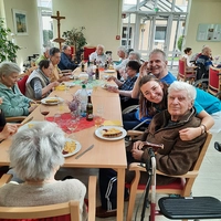 Seniorinnen und Senioren an Tischen im Pavillon.