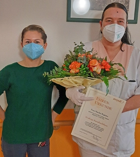 Marika Regista mit Blumen und Urkunde sowie Heimleiterin Sabrina Aristow.