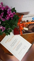 Urkunde mit Schokolade und Blumen im Hintergrund