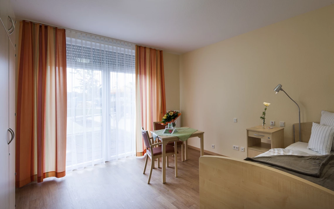 Centro Verde großzügiges Einzelzimmer, Bett, Tisch, großes Fenster mit Gardinen