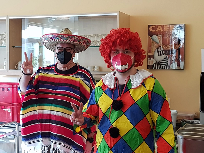 Als Clown und Mexikaner verkleidete Mitarbeitende