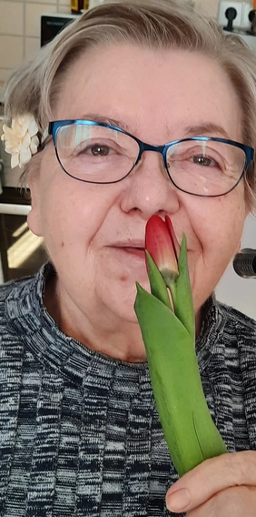 Bewohnerin der WALDSIEDLUNG freut sich über Tulpe zum Weltfrauentag.