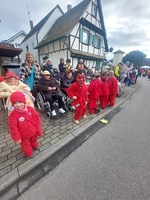 Kostümierte Bewohnerinnen im Rollstuhl am Straßenrand