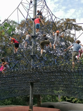 Kinder klettern auf einem Klettergerüst