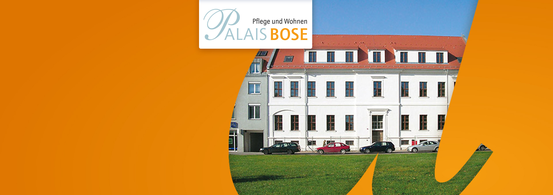 Pflege und Wohnen im Palais Bose: Rückansicht des weißen Gebäudes mit Autos davor, über eine Wiese fotografiert.
